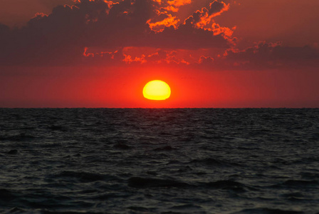 日落在水面上, 太阳在地平线上落下照片