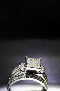 镶有光泽反光的盒子里的钻石订婚戒指。闪闪发光的公主切割钻石。