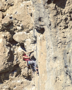 年轻的女性攀岩者在悬崖上。