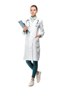 自信的年轻女医生穿着医用外套，拿着剪贴板，隔离在白色的