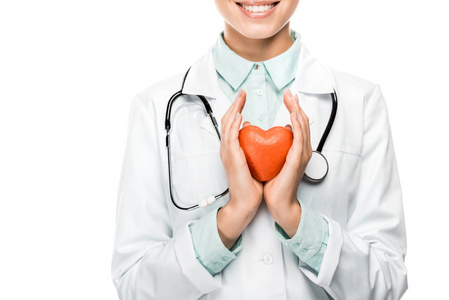 幸福年轻的女医生用听诊器在脖子上剪下的图像显示了在白色上分离的心脏符号