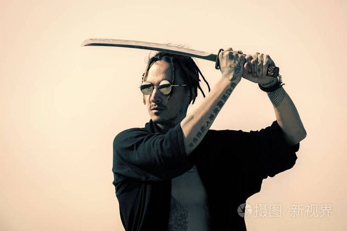 人用武士刀剑站在灰色的天空