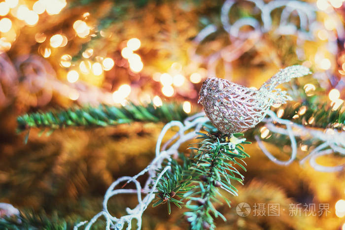 圣诞树枝上装饰着一只金色的圣诞鸟。