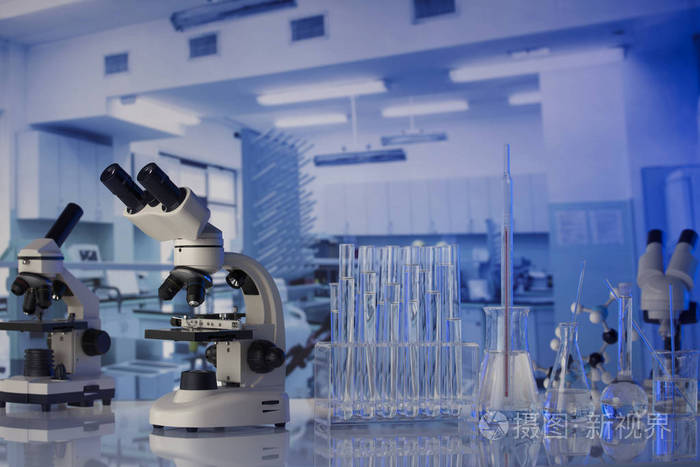 现代科学实验室内部. 玻璃桌上的实验室玻璃器皿和显微镜.照片-正版商
