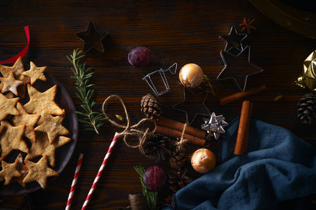 带有姜饼饼干和肉桂棒的盘子，上面有木制背景的圣诞概念装饰