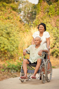 老年妇女推着轮椅上的残疾腰带图片