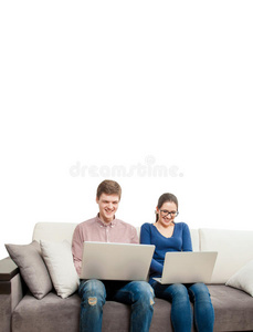 一对夫妇坐在沙发上拿着笔记本电脑