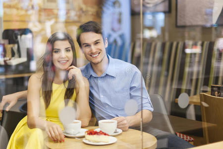 咖啡厅橱窗后的微笑情侣图片