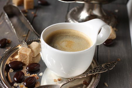 一杯浓缩咖啡方糖和巧克力糖，原木背景