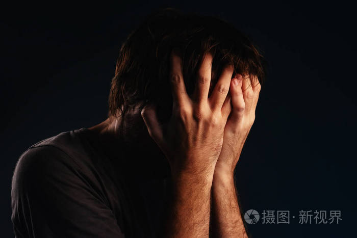 男人绝望地哭泣双手捂脸低键肖像