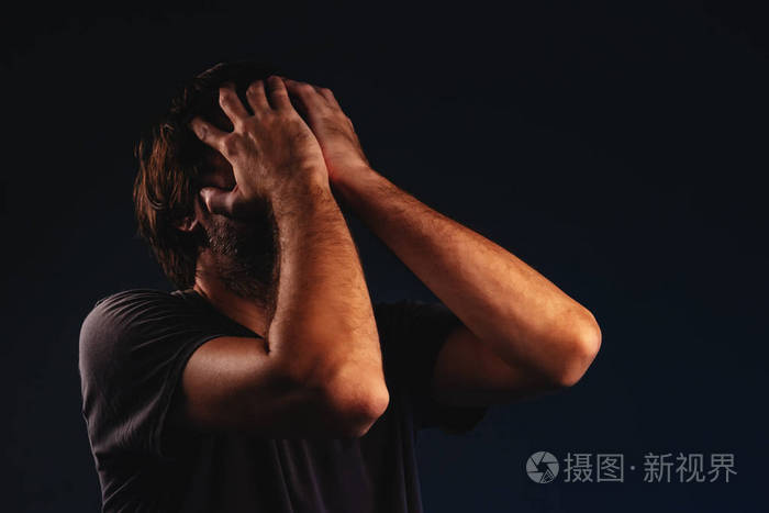 男人绝望地哭泣双手捂脸低键肖像