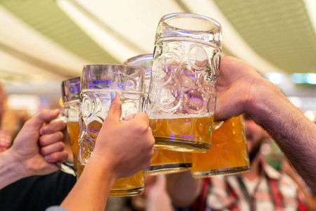 一群年轻人的朋友在德国啤酒节上举杯祝酒。浅自由度