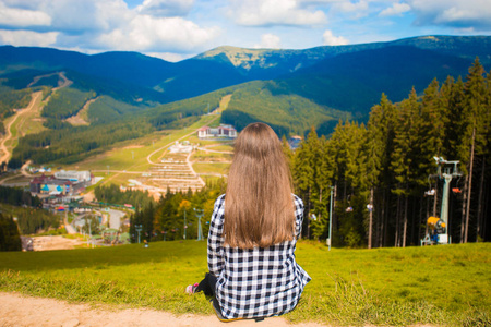 徒步旅行者女人的后景躺在山顶的草地上。 旅行概念