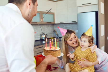 一个有蛋糕的家庭祝贺他生日快乐的孩子。