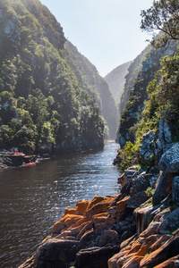 深河峡谷自然景观与一群人在独木舟上的遥远背景。