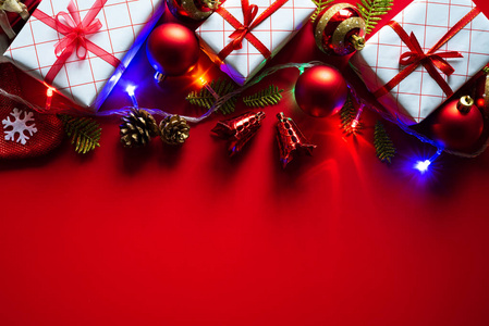 圣诞节背景概念。 圣诞礼品盒，红色背景上有红色的球和松果。