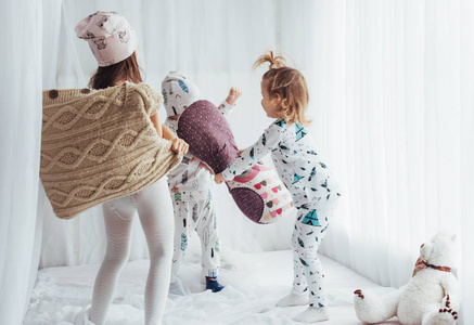 穿着柔软温暖睡衣的孩子们在床上玩耍
