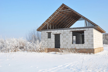 冬天的房子建设。 未完成的家庭屋面金属瓷砖施工。 冬季屋面施工。