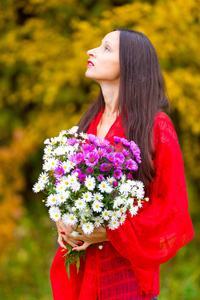 秋天公园里有一束花的漂亮女人