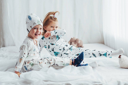 穿着柔软温暖睡衣的孩子们在床上玩耍