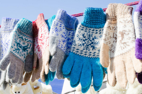 手套在冬季圣诞节市场。 各种五颜六色的羊毛手套挂在绳子上。 圣诞礼物或纪念品。