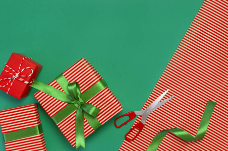 礼品盒包装纸剪刀丝带绿色背景。 节日背景祝贺礼物包装圣诞节和新年主题。 平躺式顶部视图