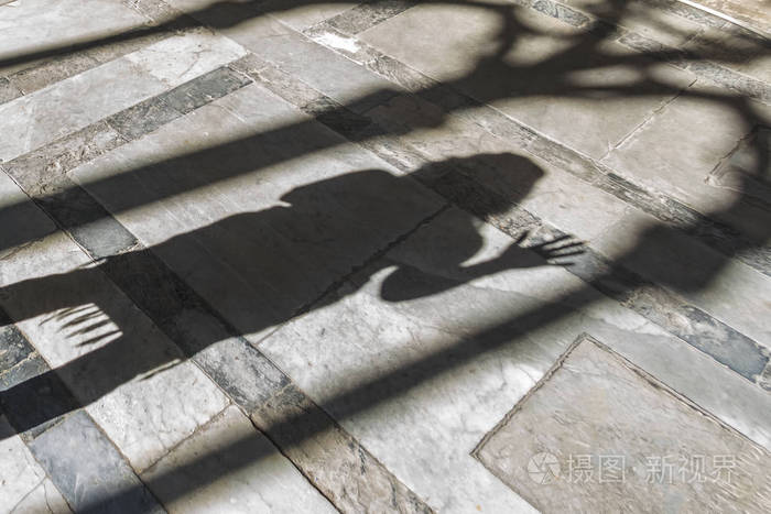 一个女人在石头地板上的影子