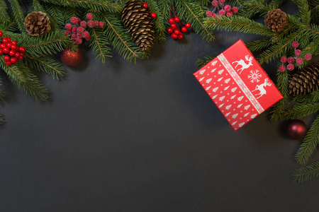 圣诞节背景树礼物冬青浆果和装饰在一个黑色的棋盘上。 带有复制空间的假日卡。 上面的风景。