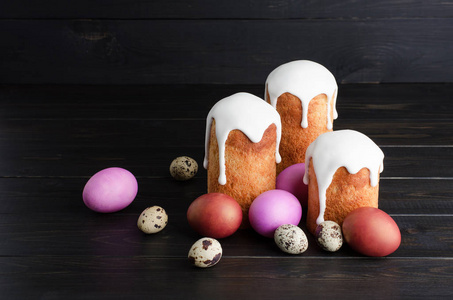 复活节还活着。 复活节蛋糕和鸡鹑蛋在一个黑暗的乡村木制背景。