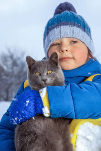 男孩在冬天在户外玩猫专注于猫