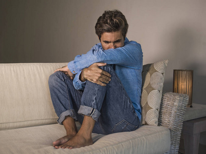 生活方式肖像年轻,有魅力,英俊,悲伤的拉丁男人,疲惫和沮丧地坐在家里