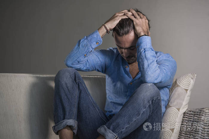 生活方式肖像年轻,有魅力,英俊,悲伤的拉丁男人,疲惫和沮丧地坐在家里