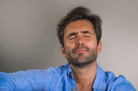 生活方式肖像年轻,有魅力,英俊,悲伤的拉丁男人,疲惫和沮丧地坐在家里