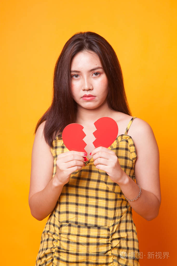 美丽的年轻亚洲女人,心碎的黄色背景照片-正版商用图片13cthn-摄图新
