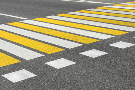 沥青道路人行横道,标线为白色和黄色条纹照片