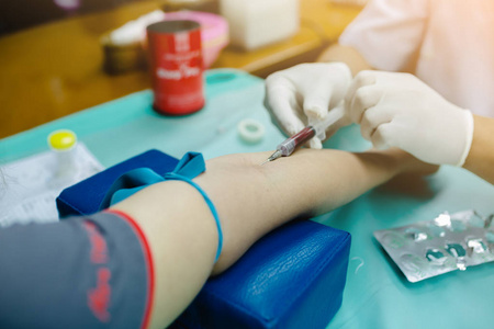选择性和关闭护士在手臂中刺针注射器，病人抽取血样进行血液测试。