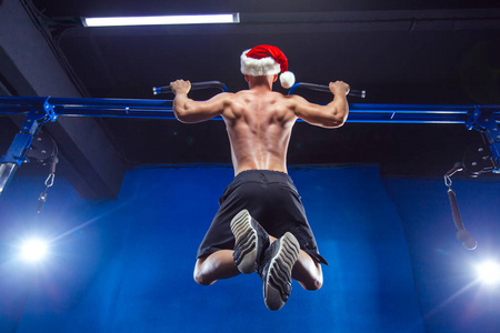 节日和庆典, 新年, 圣诞节, 体育, 健美, 健康的生活方式肌肉英俊的圣诞老人。运动员肌肉健身男性模型在健身房水平杆上的