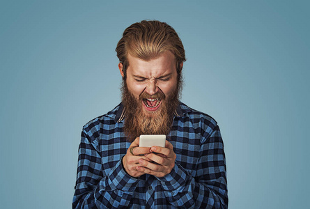 愤怒的小男孩对着手机尖叫.