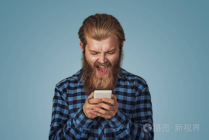 愤怒的小男孩对着手机尖叫.