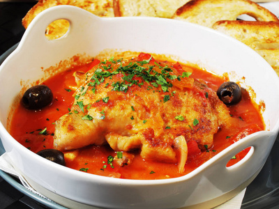 在白碗里用番茄酱炖的鸡肉照片