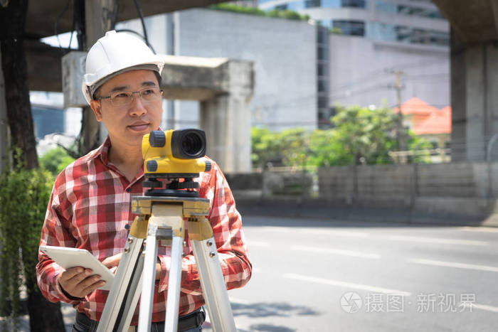 土木工程师用测头仪或经纬仪设备进行土地测量.