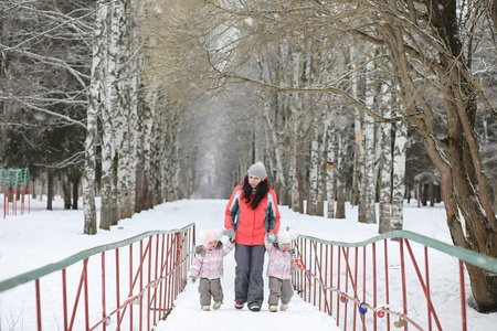 冬天孩子们在公园里散步。冬天森林家庭与