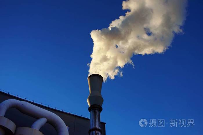 白色烟雾从带有蓝天背景的金属工业烟囱出来。 空气污染温室效应与全球变暖问题的概念。
