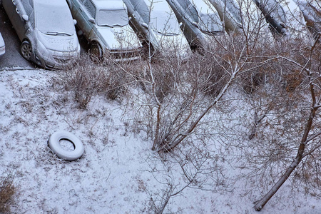 住宅区的降雪覆盖了草坪和停放的汽车