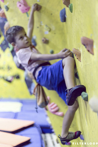 自由登山儿童在体育馆巨石上练习人造巨石