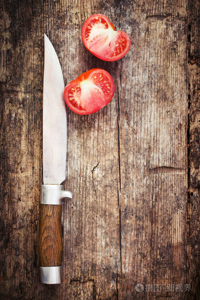 把刀和番茄放在木桌上