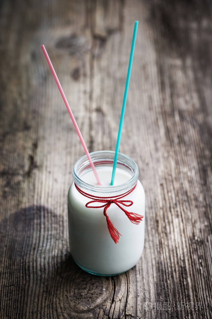 旧桌子上有吸管的复古牛奶
