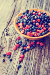 成熟的草莓和蓝莓放在木碗里