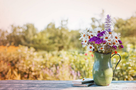 花瓶中的野花矗立在木桌上，背景模糊
