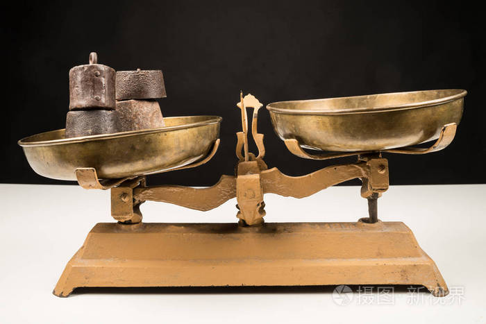 在黑白背景的老式天平和重量的侧视图